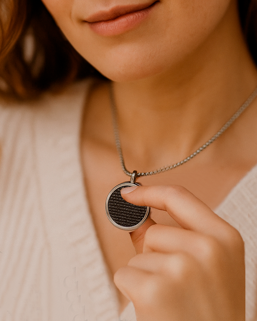 Close-up of a model holding the textured pendant Stimm necklace